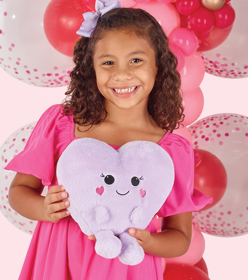 Girl holding a teddy bear next to a teddy bear balloon